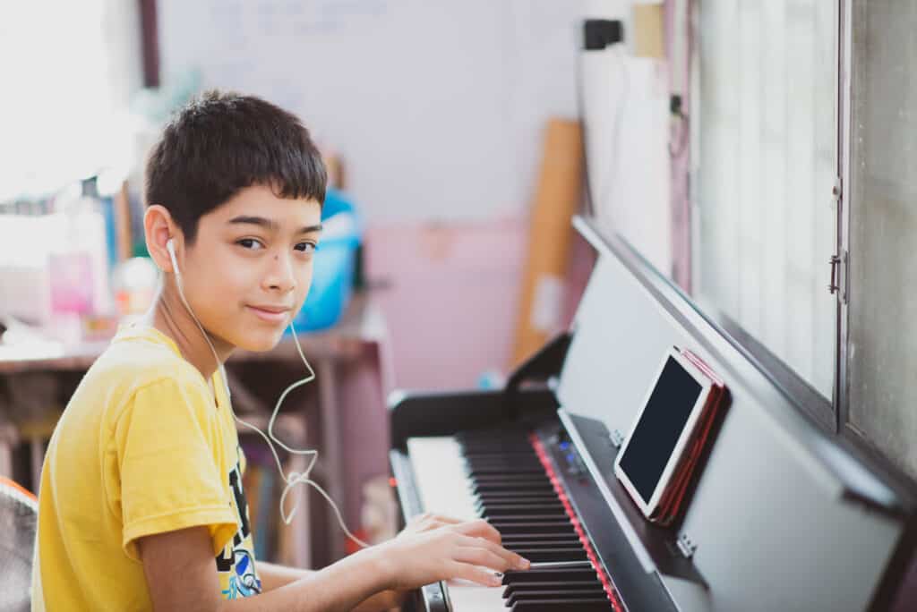 A student practicing piano for a middle school music elective course