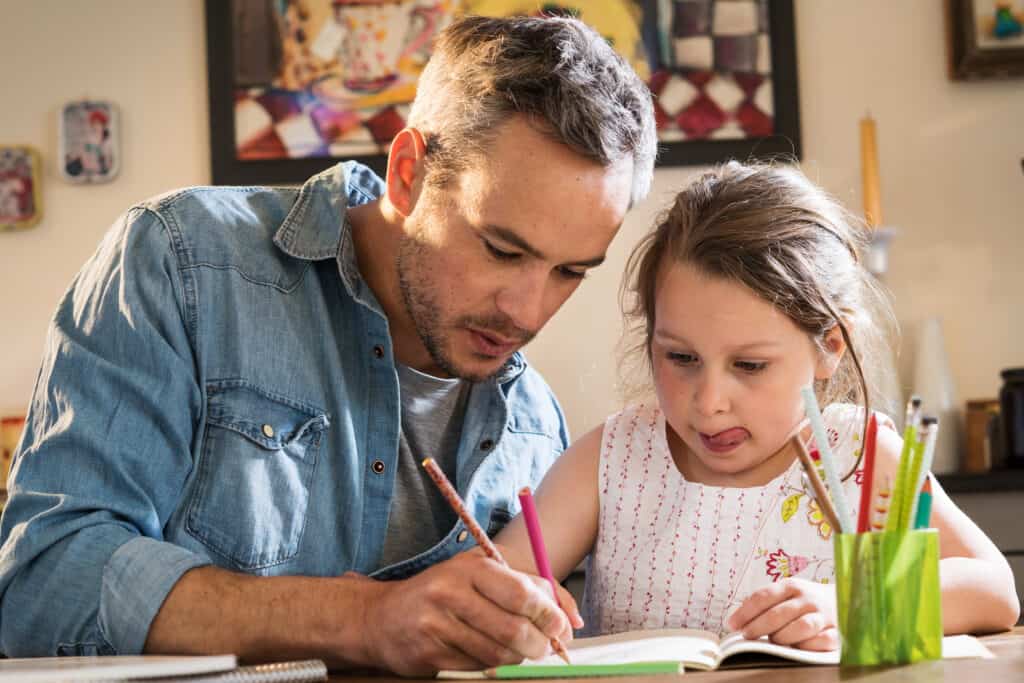 Father helping his young daughter with homework