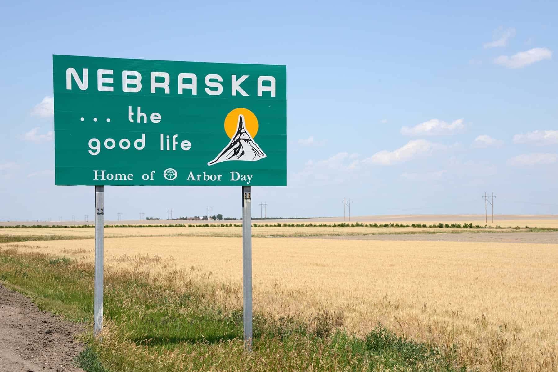 Road sign next to a field that says "Nebraska...the good life"