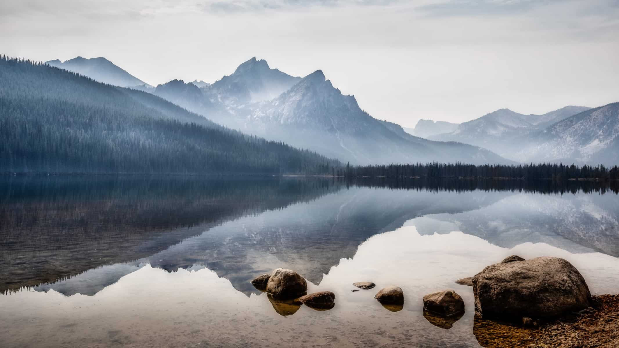 Reflection of Sawtooth Mountains on a clear lake