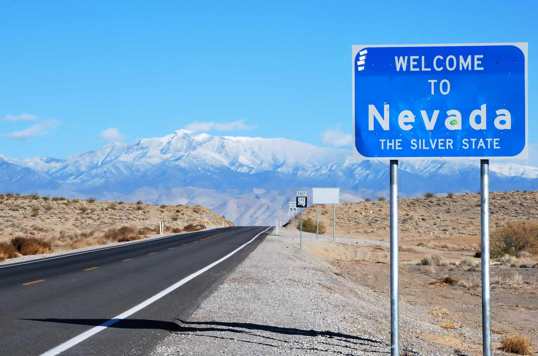 Blue road sign that says "Welcome to Nevada"