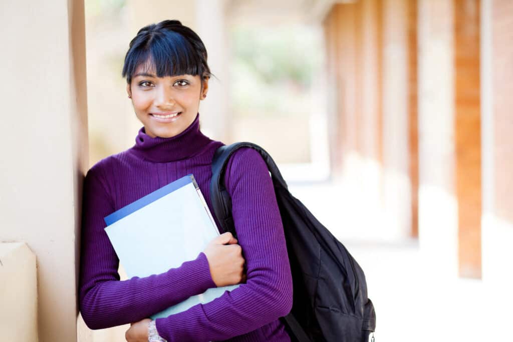 Female high school student with a backpack holding notebooks