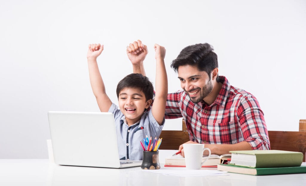 Young boy and his father using a laptop together to study online