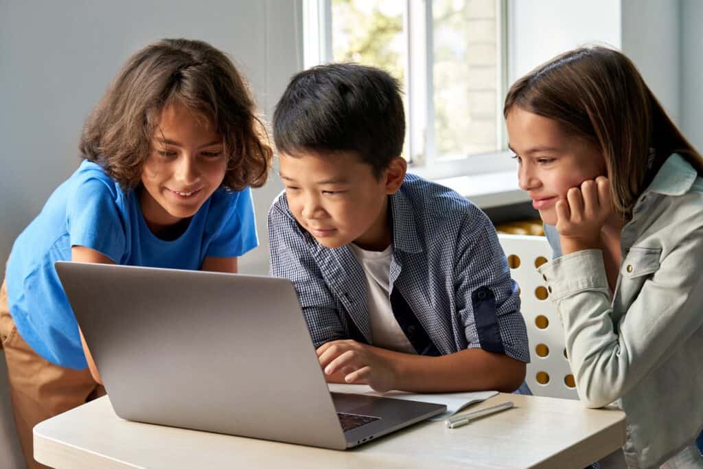 Three students doing an assignment together on a laptop