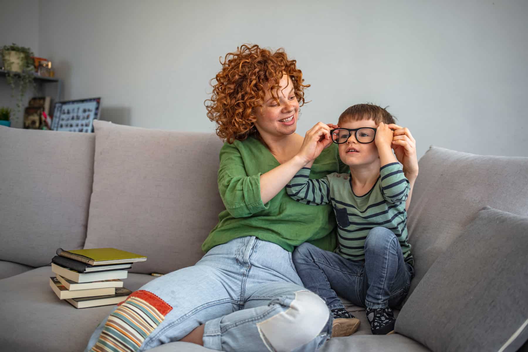 Mom helping her son try on a pair of sunglasses