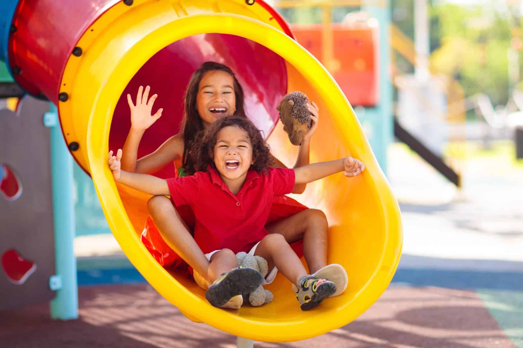 Two children in a slide at the playground