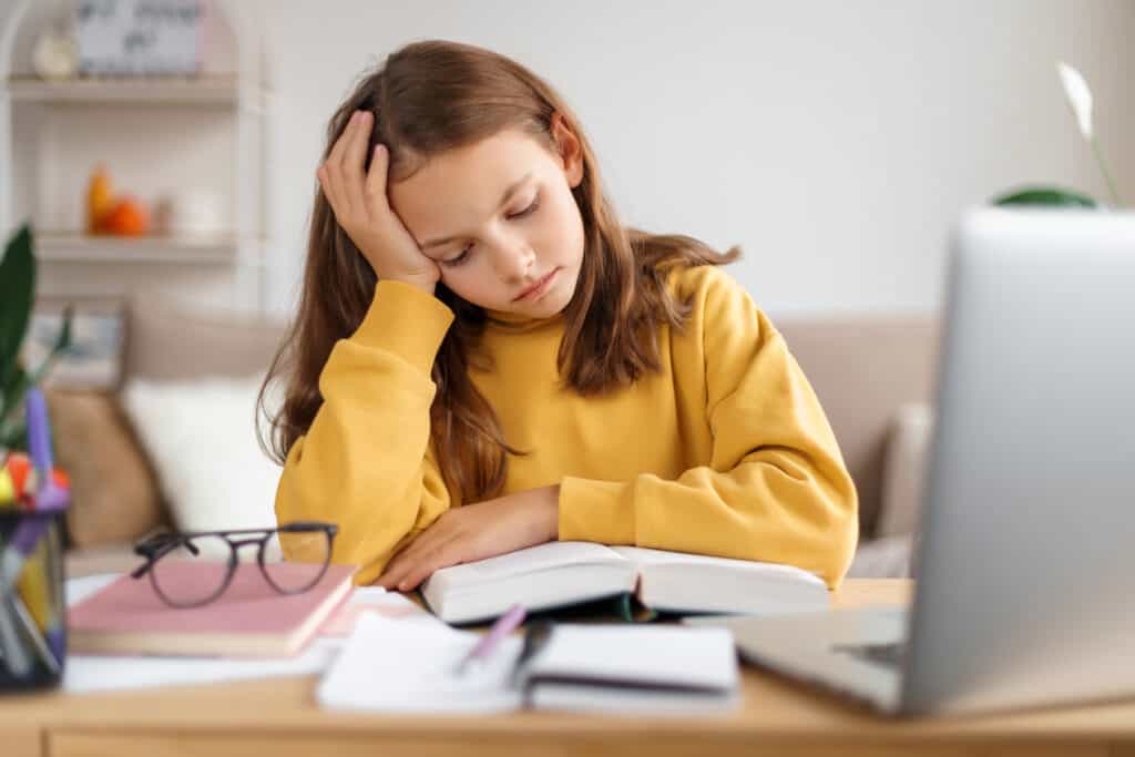 Little girl with her head in her hands, frustrated with homework