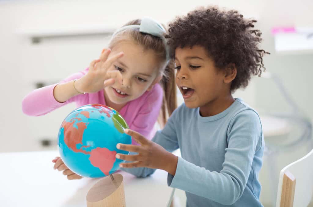 two kids holding a globe