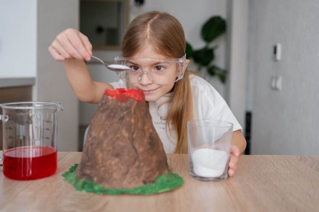 Little girl making a baking soda volcano science experiment