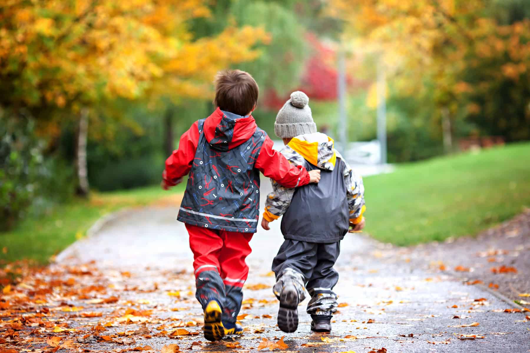 two kids wearing rainboots on a fall day