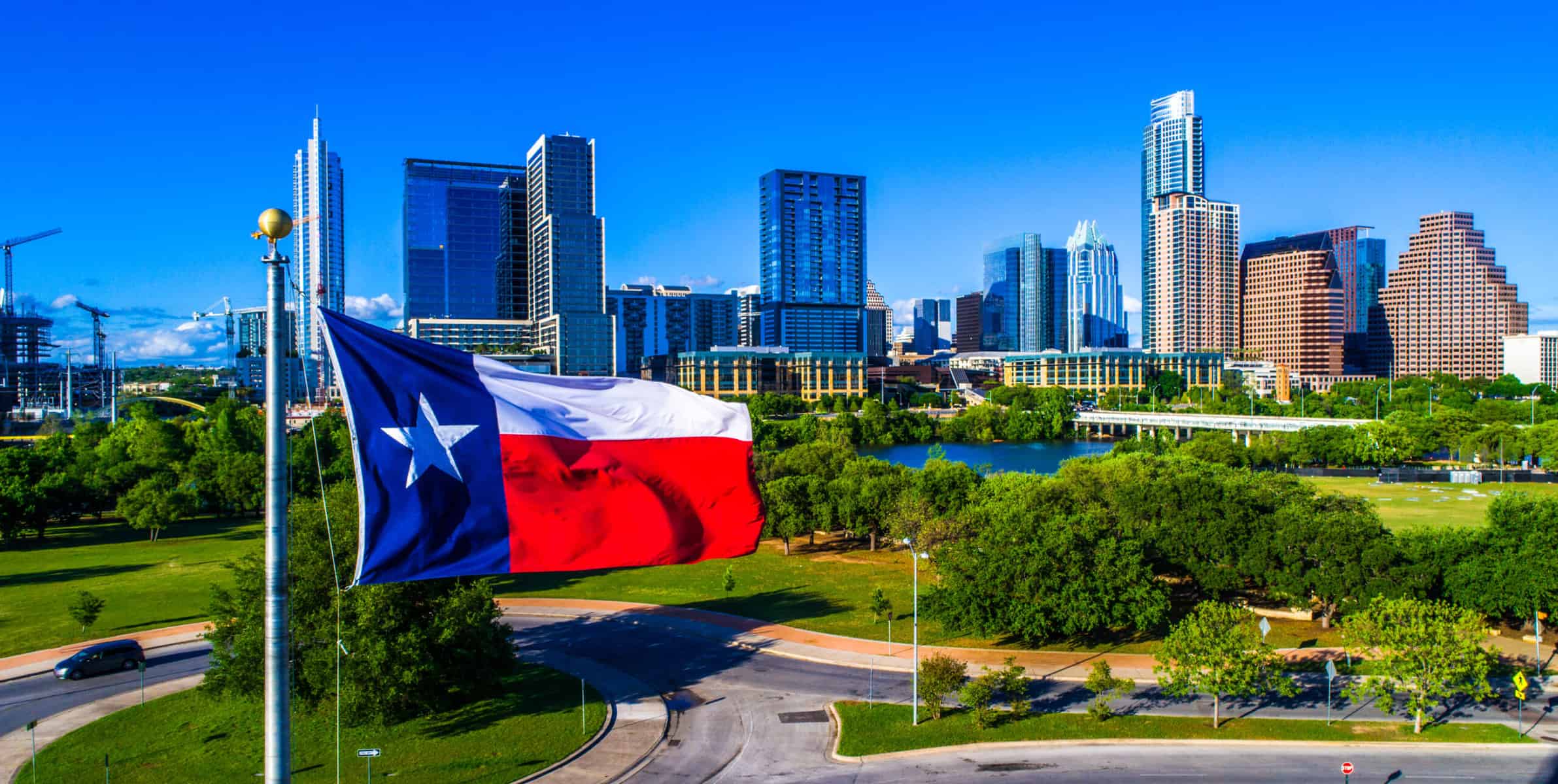 Texas flag waving over Austin city skyline
