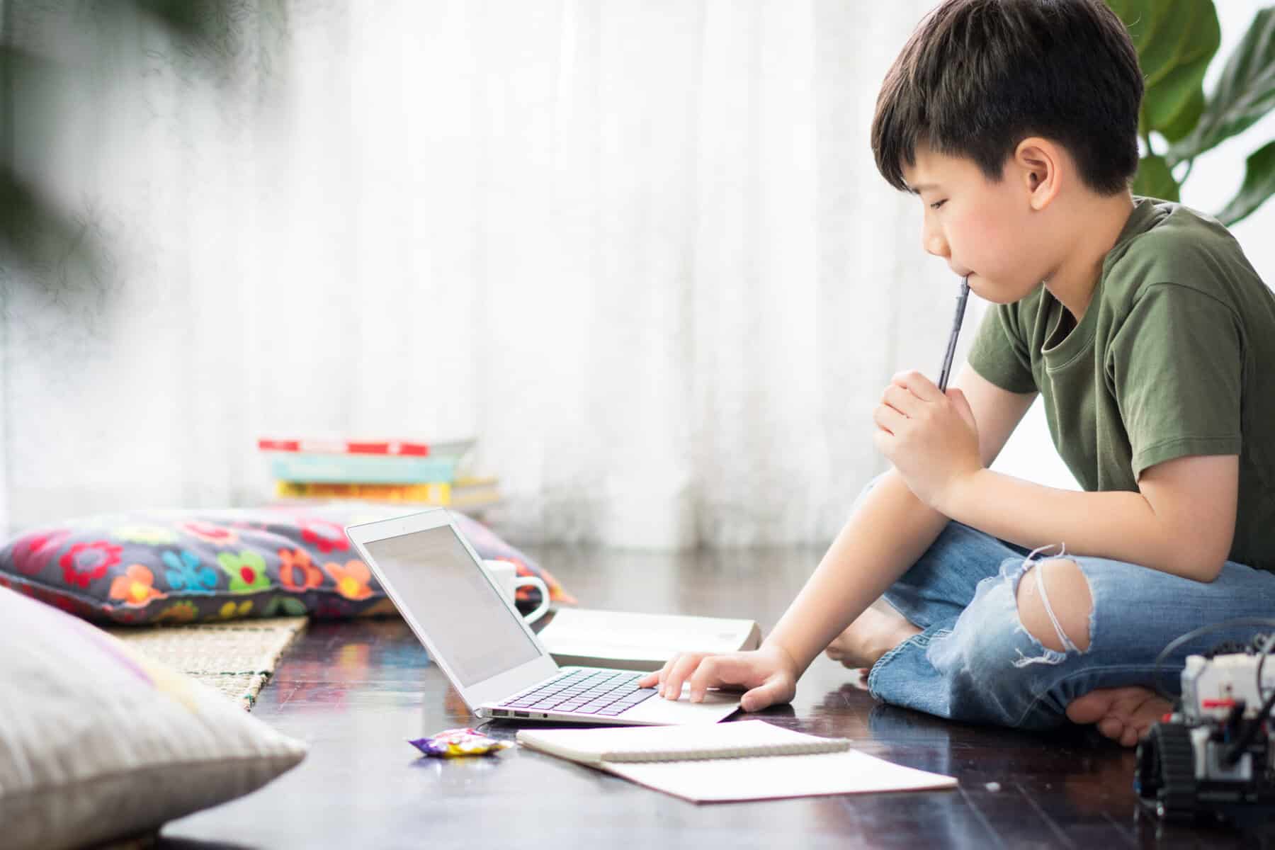 Young boy using a laptop on the floor