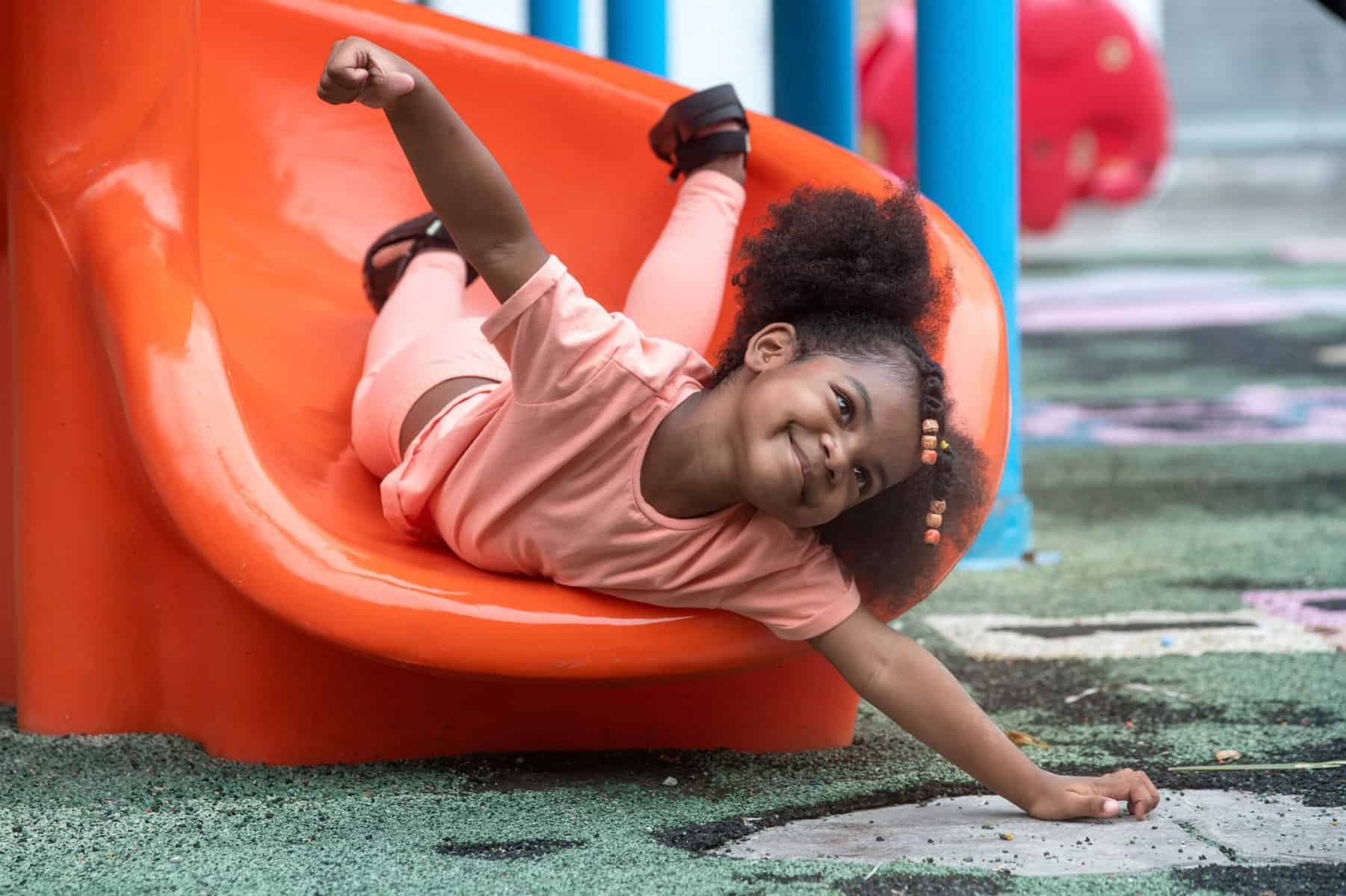 Little girl playing on a slide