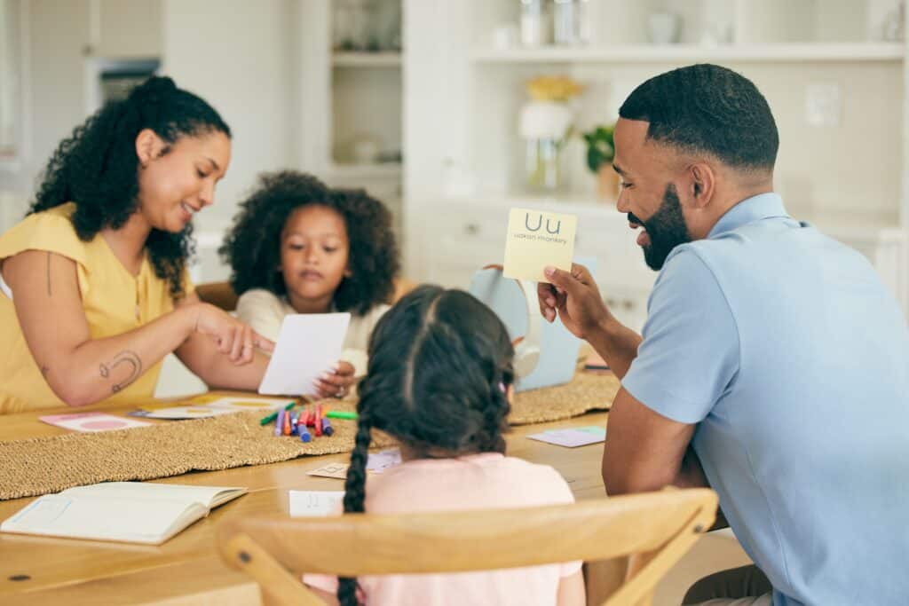 Family with two young children reviewing flash cards at the table